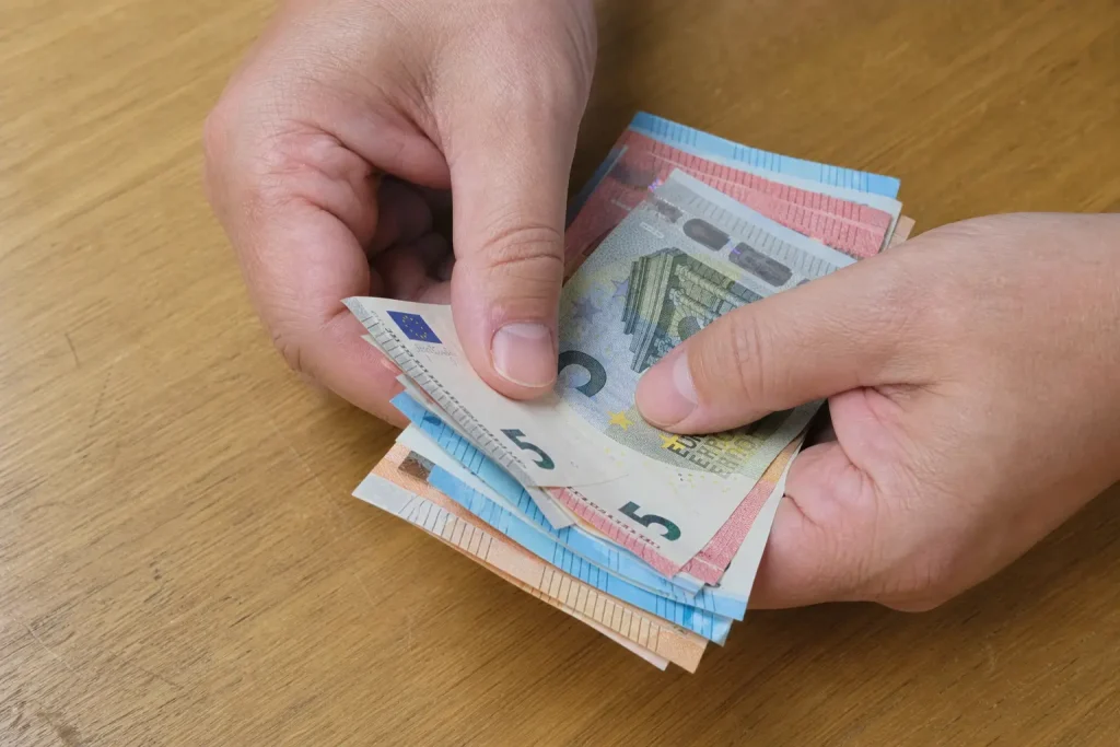 Händer som räknar eurosedlar på ett träbord i samband med Revolutionrace slukar Icaniwill värderas till 700 miljoner.