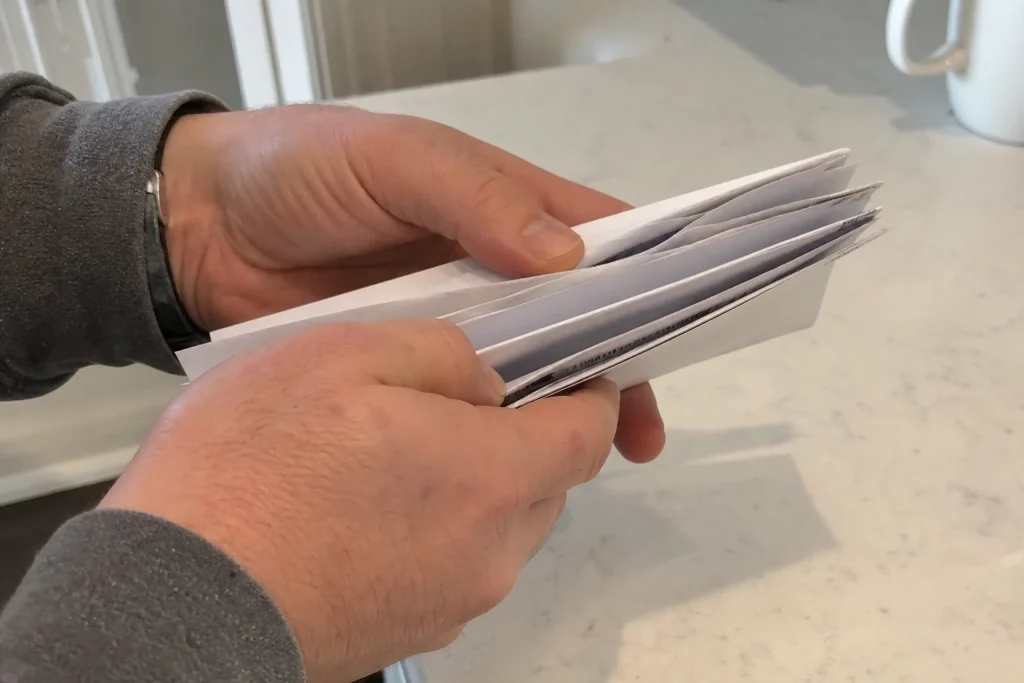 Händer som håller i ett litet knippe pappersbaserade kontoutdrag, illustration till Jonas Fröberg: Sven Hagströmer väjer f...