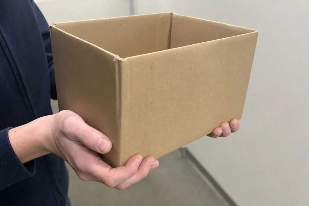 Händer som bär en tom kartongbox i en korridor efter att EA-chefens bonus ökade med 300 miljoner kronor efter uppsägningarna.